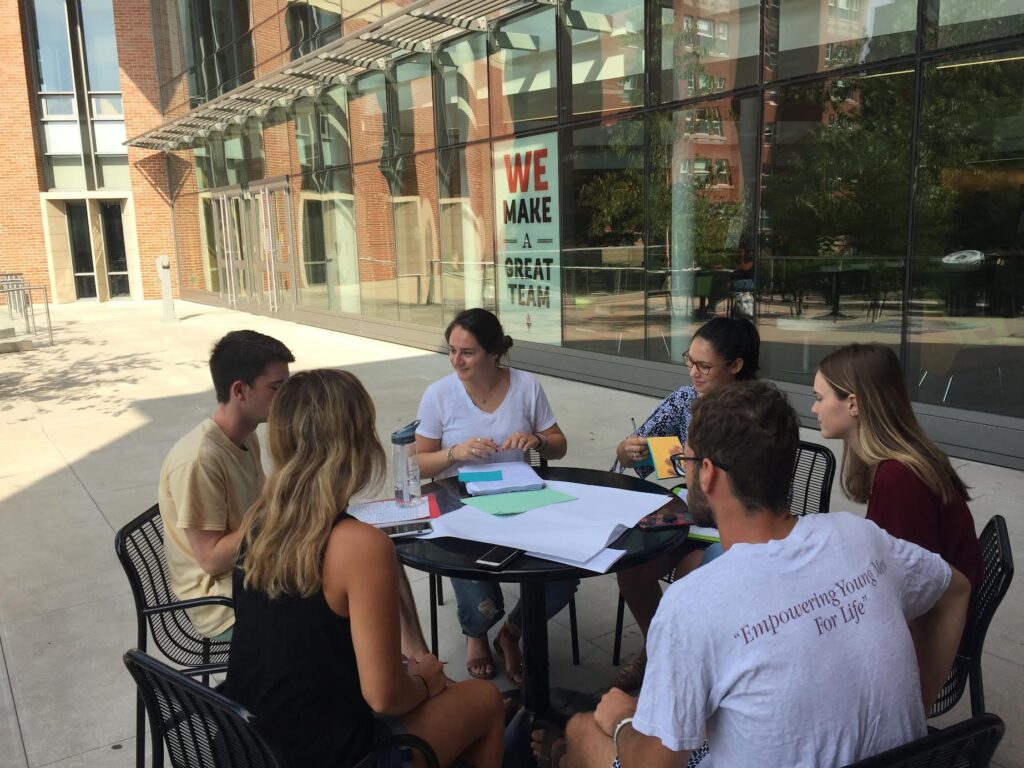 Students completing a class activity around a table. 